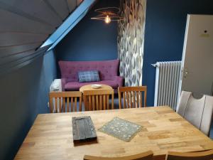 ein Esszimmer mit einem Tisch und einem lila Sofa in der Unterkunft Mariennest in Jever + 29 Fotos
