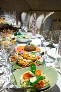 a table with plates of food and wine glasses at Hotel Elanza Suites by Signature Stayz Near Delhi Airport in New Delhi