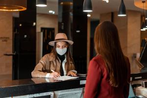 a woman in a hat and a man in a mask at Hotel Elanza Suites by Signature Stayz Near Delhi Airport in New Delhi