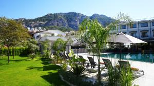 a resort with a pool and chairs and a building at Göcek Lykia Resort Premium Concept Hotel in Göcek