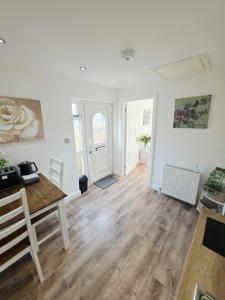 a living room with a table and a wooden floor at Kents Hill Studio in Woolstone