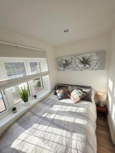 a bedroom with a large bed and two windows at Kents Hill Studio in Woolstone
