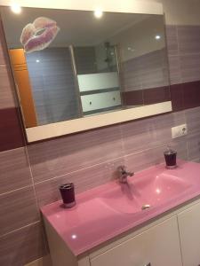 a pink sink in a bathroom with a mirror at La magia de Benjamín in Oviedo