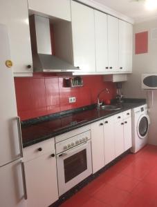 a kitchen with white cabinets and a stove top oven at La magia de Benjamín in Oviedo