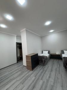 a room with two beds and a desk in it at Bank Hotel in Yeghegnadzor
