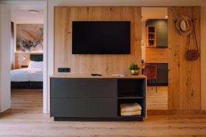 a living room with a television on a wall at Appartementhaus Absmeier in Bad Füssing