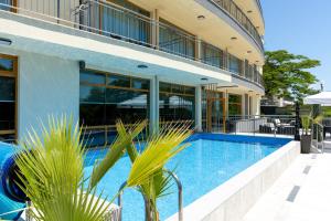 a building with a swimming pool in front of a building at Hotel Trezor in Varna City