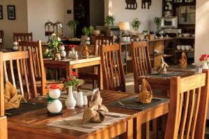 ein Esszimmer mit Holztischen und Stühlen mit Blumen in der Unterkunft Onrock Boutique Hotel in Ella
