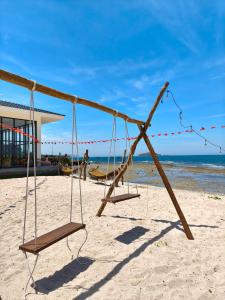 an empty swing set on the beach at Hon Do Eco Retreat in Mỹ Thanh +35 photos
