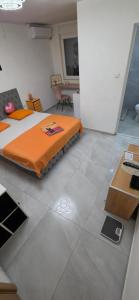 a bedroom with a bed and a desk in it at Maca apartman 23 in Petrovaradin