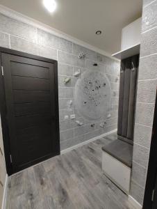 a hallway with a black door and a tile wall at Apartments in Taraz +5 photos