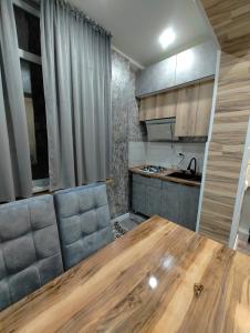 a kitchen with a wooden table in a room at Apartments in Taraz