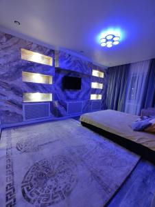 a bedroom with a bed and a stone wall at Apartments in Taraz