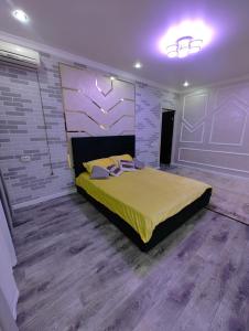 a bedroom with a large bed in a room with wooden floors at Apartments in Taraz
