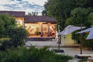 a house with an umbrella in front of it at Hotel & Wine Cellar ARGE in Telavi