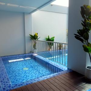 a swimming pool in a room with a balcony at NH Residence Yogyakarta in Ngabean