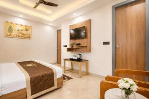 a bedroom with a bed and a table and a tv at Hotel Elanza Suites by Signature Stayz Near Delhi Airport in New Delhi