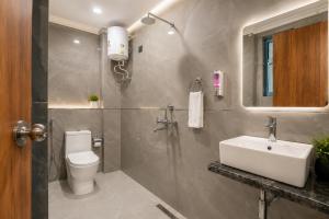 a bathroom with a sink and a toilet and a mirror at Hotel Elanza Suites by Signature Stayz Near Delhi Airport in New Delhi +28 photos