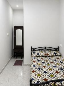 a bedroom with a bed with a quilt and a mirror at D stays in Alāndurai