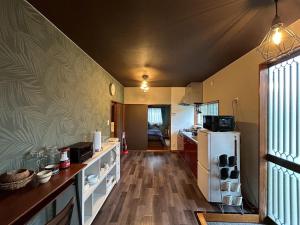 a kitchen with a white refrigerator and a wooden floor at Kawazu Sakura-so in Kawazu