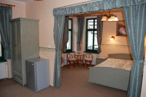 a bedroom with a bed and a table and chairs at Penzión Zuzi in Martinske Hole