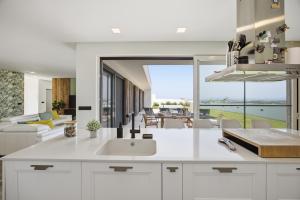 a kitchen with a sink and a living room at Al Casa Branca in Lourinhã