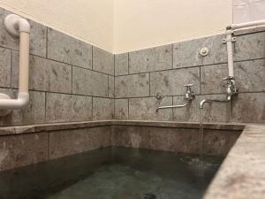 a bathroom with a tub with water in it at Kawazu Sakura-so in Kawazu +62 photos