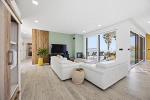 a living room with white furniture and large windows at Al Casa Branca in Lourinhã