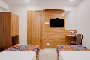 a hotel room with two beds and a tv at FabHotel Shaurya Inn MIDC in Ghansoli