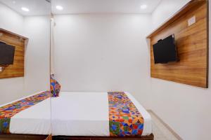 a bedroom with a bed and a tv on the wall at FabHotel Shaurya Inn MIDC in Ghansoli +44 photos