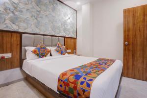 a bedroom with a bed and a painting on the wall at FabHotel Shaurya Inn MIDC in Ghansoli