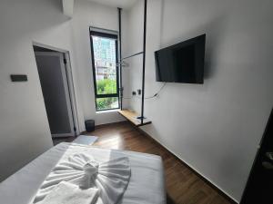 a white room with a television and a bed at Hotel O Rosegold Garden in Kuantan