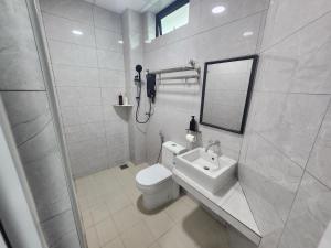 a white bathroom with a toilet and a sink at Hotel O Rosegold Garden in Kuantan +22 photos