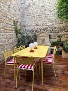 a yellow table with chairs and a table with two lamps at Plumard in Arles +22 photos