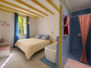 a bedroom with a bed and a bath tub and a tub at Plumard in Arles