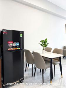 a dining room with a table and a black refrigerator at Cara River Park in Cái Răng