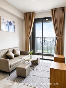 a living room with a couch and a large window at Cara River Park in Cái Răng