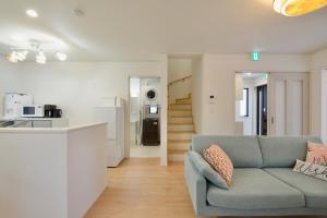 a living room with a couch and a kitchen at 北谷町港2 in Chatan