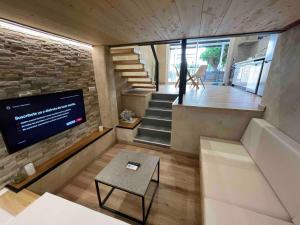 a room with a staircase and a tv in a house at Can Padrosa Mini Loft 1 in Riumors