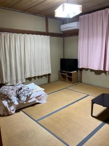 a room with a bed in a room with windows at いちご荘 in Ichihara