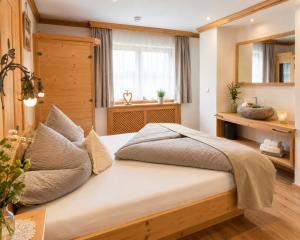 a bedroom with a large bed with a window at Haus Alpenecho in Mittelberg