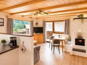 a kitchen and living room with a table and a fireplace at Haus Alpenecho in Mittelberg