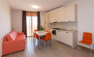 cocina y sala de estar con mesa y sillas en Residence California, en Lido di Jesolo