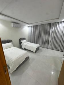 a hotel room with two beds and a window at شقق تأجير يومي in Musaylah