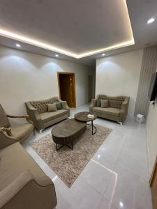 a living room with two couches and a table at شقق تأجير يومي in Musaylah