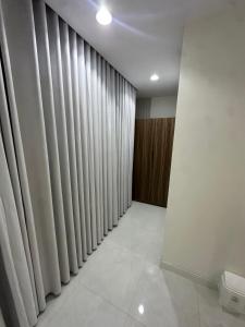 a room with vertical blinds on the wall and a room with white tiles at شقق تأجير يومي in Musaylah +1 photo