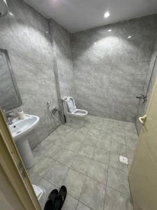 a bathroom with a toilet and a sink at شقق تأجير يومي in Musaylah