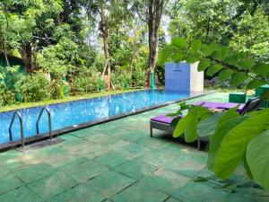 a swimming pool with a purple bed next to it at Spice Village Hotel & Restaurant in Habarana