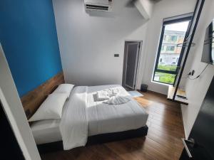 a bedroom with a white bed and a window at Hotel O Rosegold Garden in Kuantan