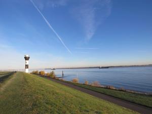 a lighthouse on the shore of a body of water at Premium-Ferienhaus Elbstar im Feriendorf Altes Land an der Elbe in Hollern-Twielenfleth